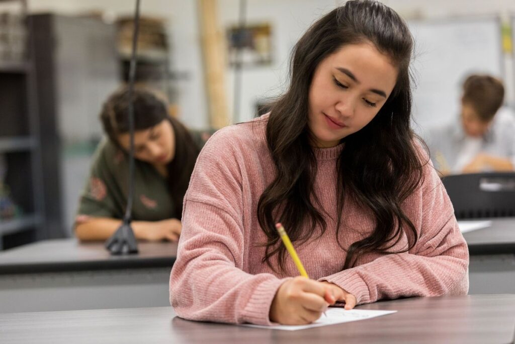 A high school student practicing effective GCSE Maths revision strategies by solving algebraic equations in a notebook